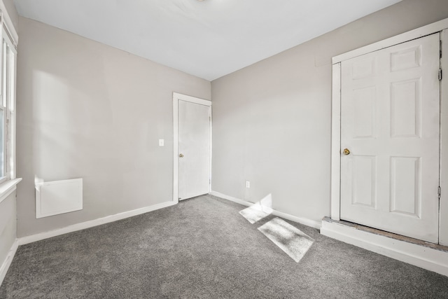 carpeted empty room with baseboards