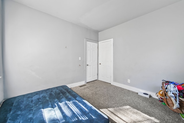 unfurnished bedroom featuring visible vents, baseboards, and carpet