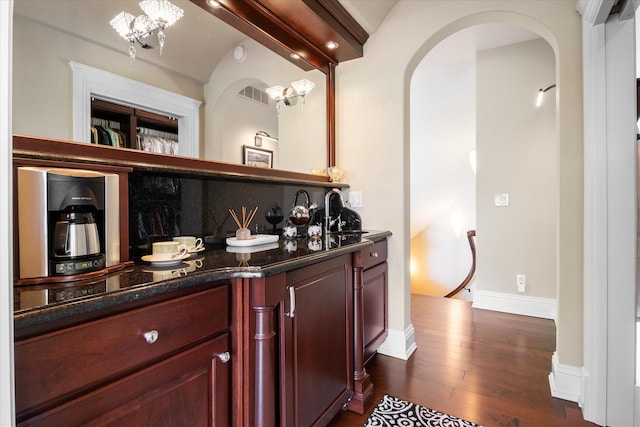 2122 Grange Rd, Buchanan, MI 49107 - bar featuring arched walkways, dark wood-type flooring, baseboards, and a sink