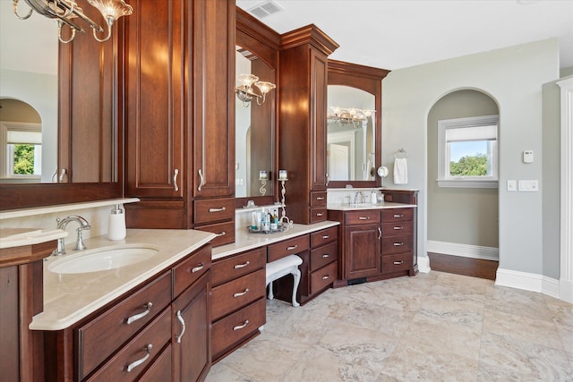 2122 Grange Rd, Buchanan, MI 49107 - full bathroom with a chandelier, baseboards, and two vanities