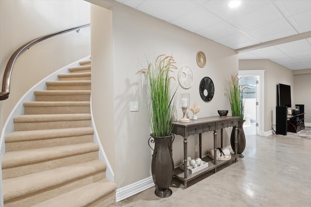 2122 Grange Rd, Buchanan, MI 49107 - stairs featuring baseboards, concrete flooring, and a paneled ceiling