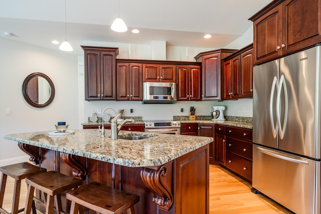 2122 Grange Rd, Buchanan, MI 49107 - kitchen with appliances with stainless steel finishes, a sink, light wood finished floors, light stone countertops, and recessed lighting