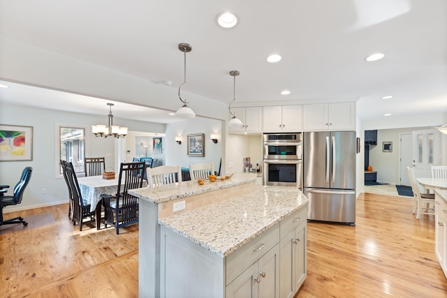 kitchen with light wood finished floors, recessed lighting, appliances with stainless steel finishes, and a center island