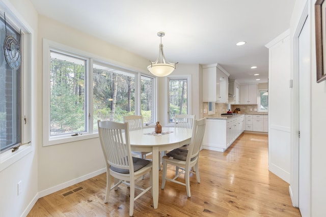 dining space with plenty of natural light, baseboards, visible vents, and light wood-type flooring