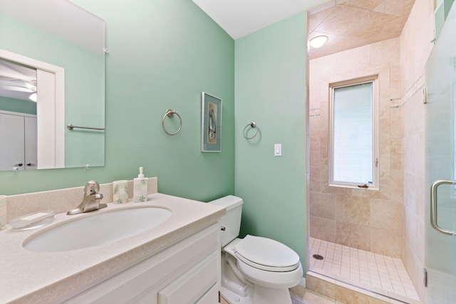 bathroom with a stall shower, toilet, and vanity