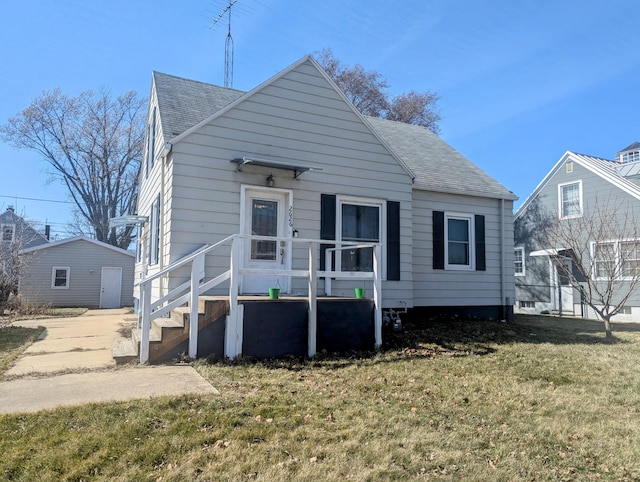 view of front facade with a front yard and roof with shingles