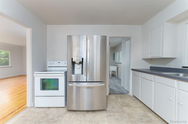 2810 Otsego Rd, Waterford, MI 48328 - kitchen with stainless steel fridge, white electric stove, and dark countertops