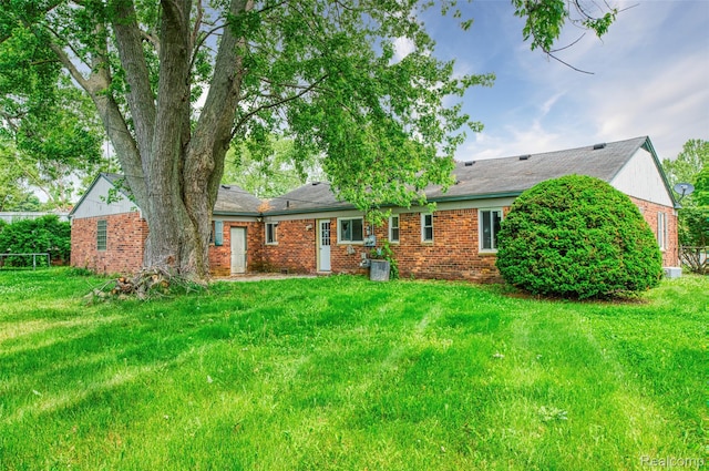 2810 Otsego Rd, Waterford, MI 48328 - back of house featuring brick siding and a lawn