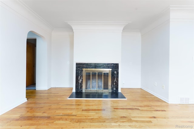 2810 Otsego Rd, Waterford, MI 48328 - detailed view of wood finished floors, arched walkways, a high end fireplace, and crown molding