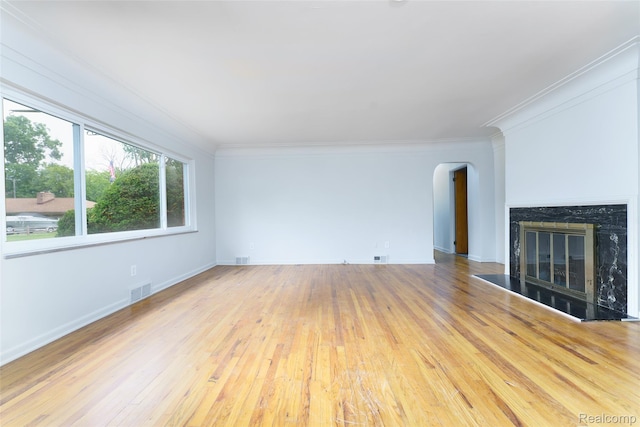 2810 Otsego Rd, Waterford, MI 48328 - unfurnished living room featuring arched walkways, wood-type flooring, crown molding, and a premium fireplace