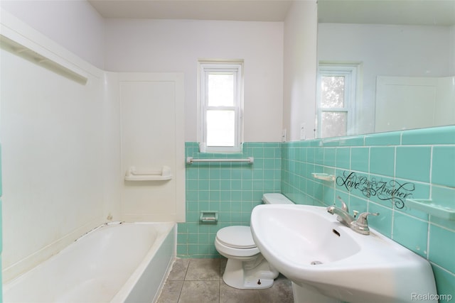 2810 Otsego Rd, Waterford, MI 48328 - full bathroom featuring healthy amount of natural light, a tub to relax in, tile patterned floors, tile walls, and wainscoting