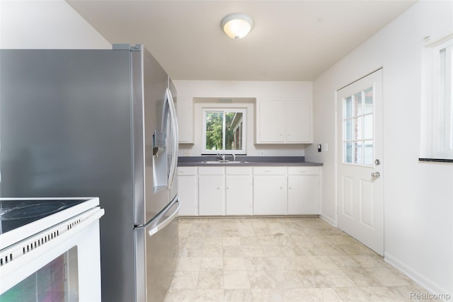 2810 Otsego Rd, Waterford, MI 48328 - kitchen with dark countertops, white cabinets, white range with electric stovetop, and stainless steel refrigerator with ice dispenser