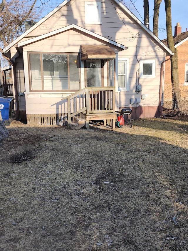 rear view of property featuring a sunroom