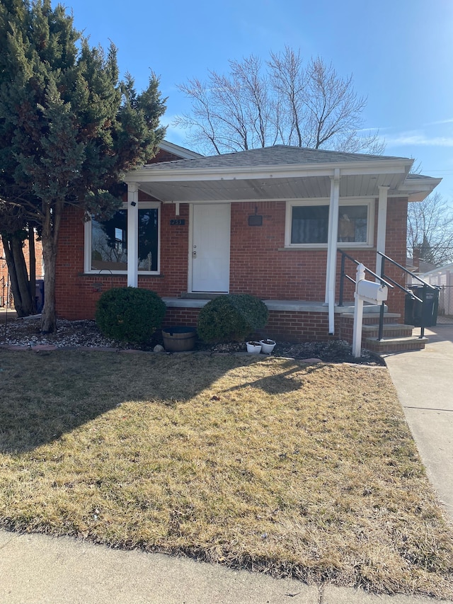 view of front facade featuring a front lawn, a porch, and brick siding