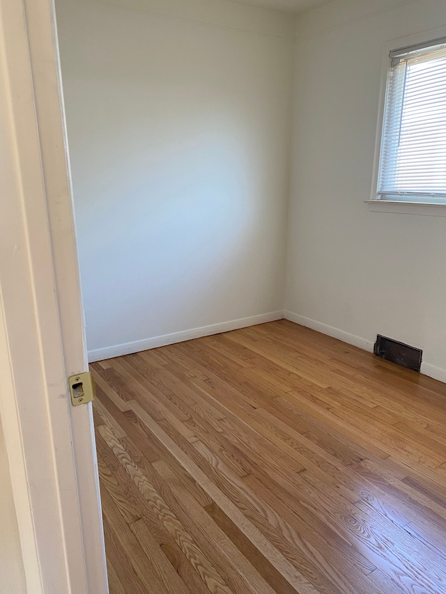 unfurnished room with baseboards and wood finished floors