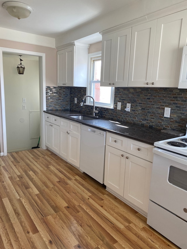 kitchen featuring tasteful backsplash, white appliances, light wood-type flooring, and a sink