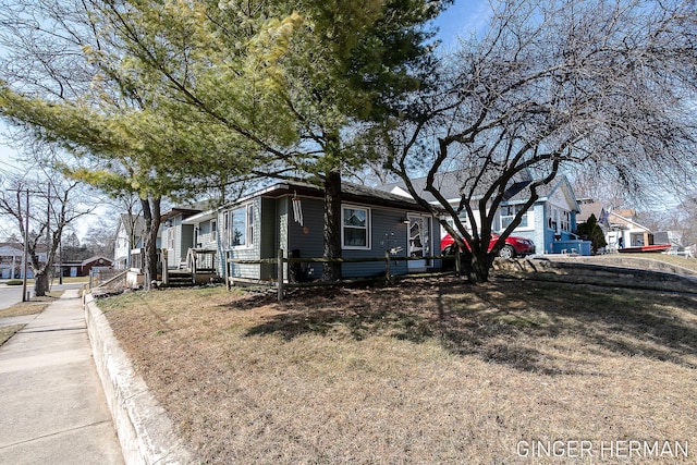 view of side of home with a residential view and a lawn