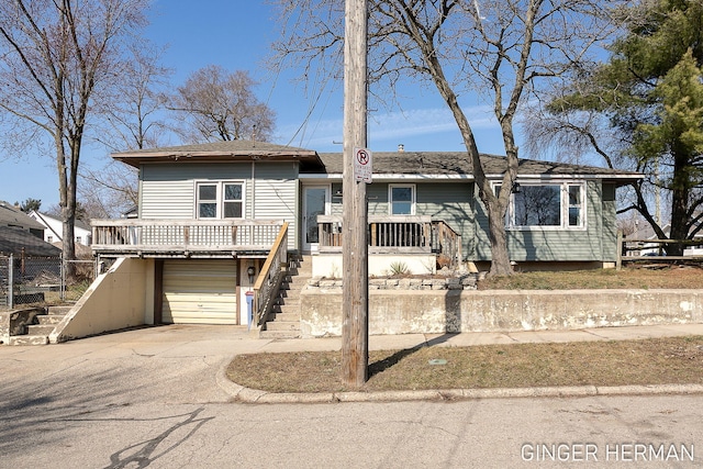 view of front of home with stairway, concrete driveway, an attached garage, and a shingled roof