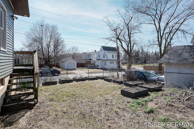 view of yard with an outbuilding, stairway, fence, and a residential view