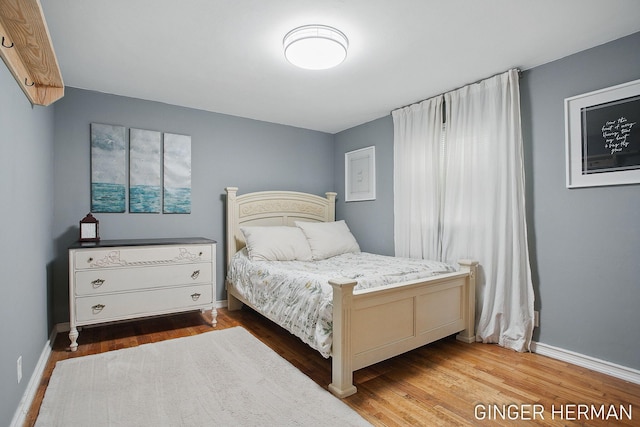 bedroom featuring wood finished floors and baseboards