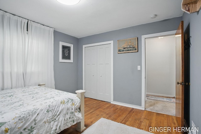 bedroom with a closet, baseboards, and wood finished floors