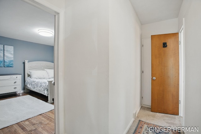 hallway with baseboards and wood finished floors