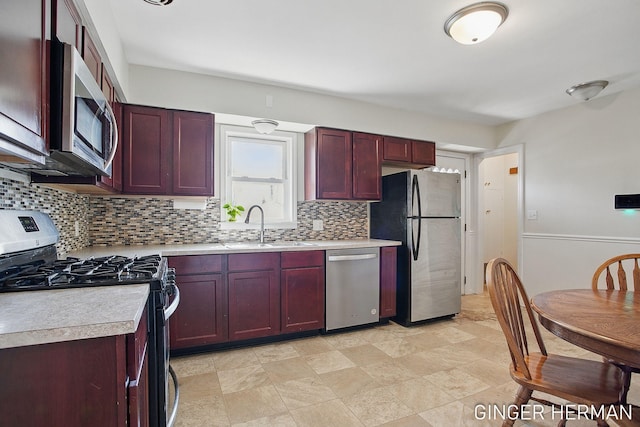 kitchen with a sink, decorative backsplash, light countertops, stainless steel appliances, and dark brown cabinets