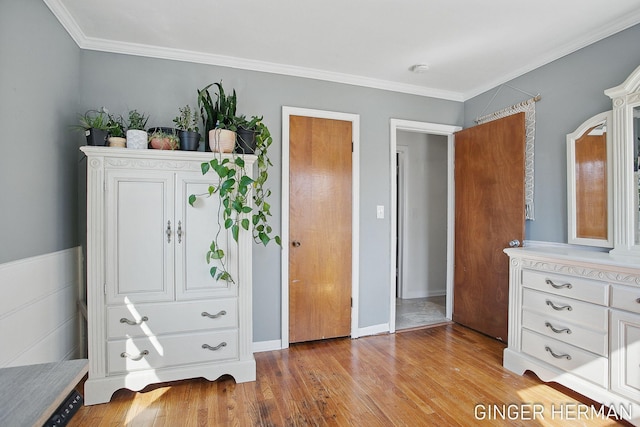 bedroom featuring baseboards, wood finished floors, and ornamental molding