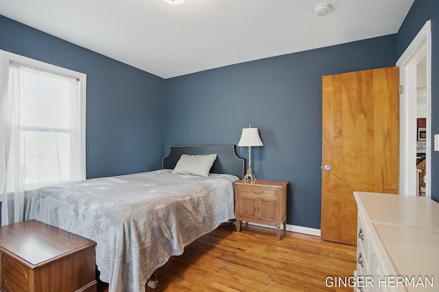 bedroom with wood finished floors and baseboards