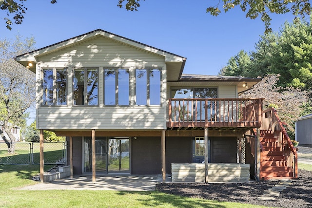 rear view of house featuring a patio, stairway, fence, a wooden deck, and a sunroom