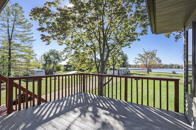 wooden terrace with a lawn and a water view