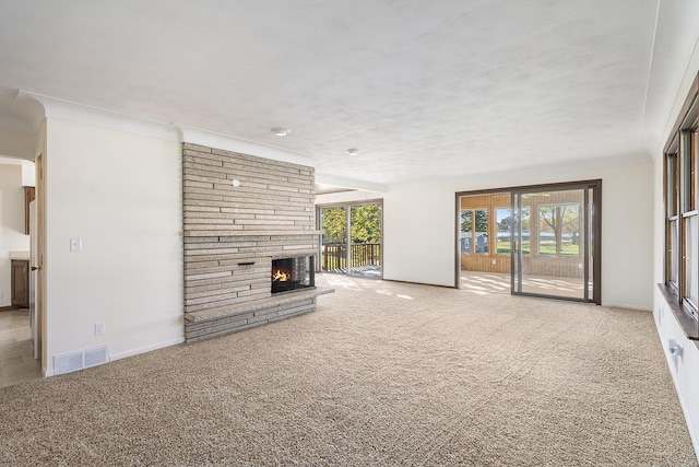 unfurnished living room featuring visible vents, carpet flooring, a fireplace, and baseboards