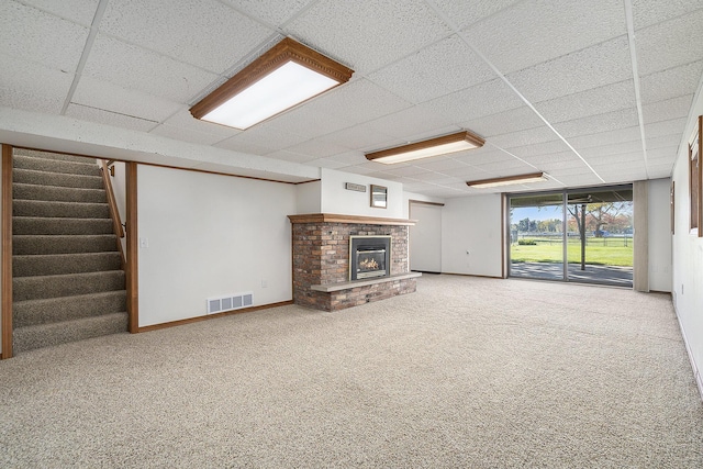 unfurnished living room with visible vents, stairway, carpet floors, a fireplace, and baseboards