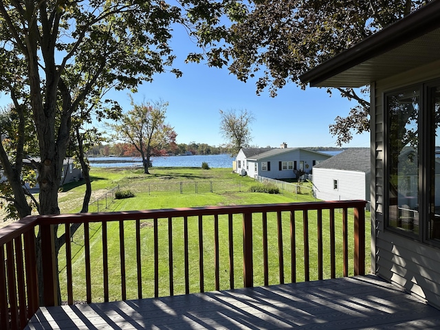 deck featuring fence, a yard, and a water view