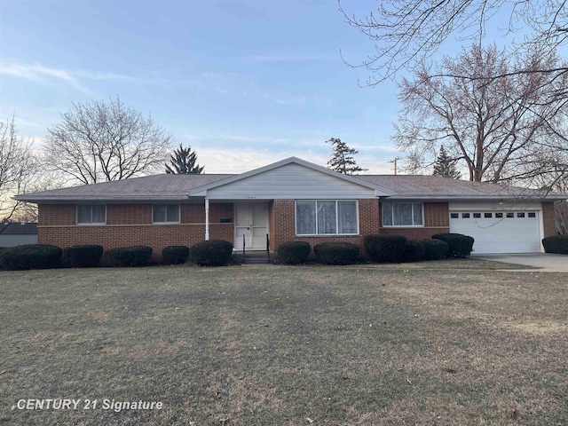 ranch-style home with a garage, a front lawn, brick siding, and driveway