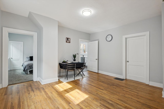 dining space with baseboards, visible vents, and wood-type flooring