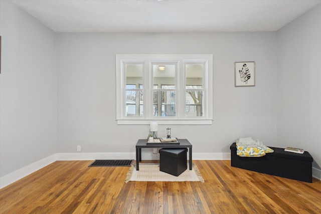 interior space with visible vents, baseboards, and hardwood / wood-style floors