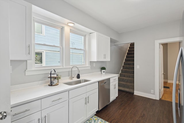 kitchen with dark wood-style floors, dishwasher, white cabinetry, and a sink