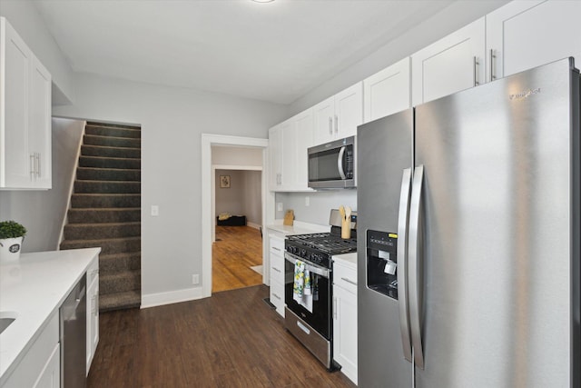 kitchen featuring baseboards, light countertops, appliances with stainless steel finishes, dark wood-style floors, and white cabinetry