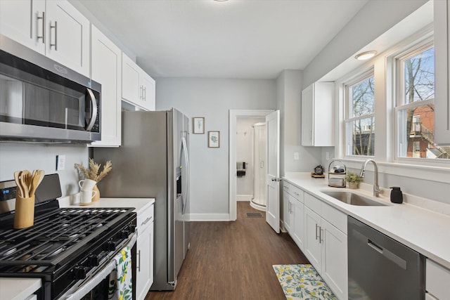 kitchen featuring a sink, light countertops, dark wood-style floors, and stainless steel appliances