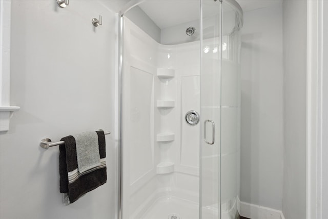 full bath featuring a stall shower and baseboards