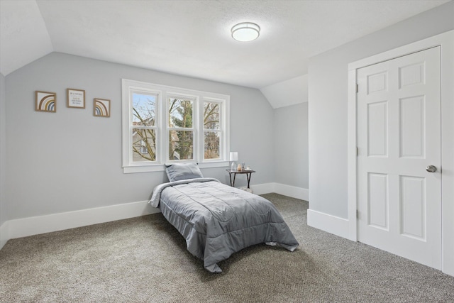 bedroom featuring baseboards, lofted ceiling, carpet, and a textured ceiling