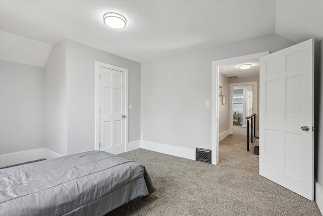 carpeted bedroom featuring baseboards and vaulted ceiling