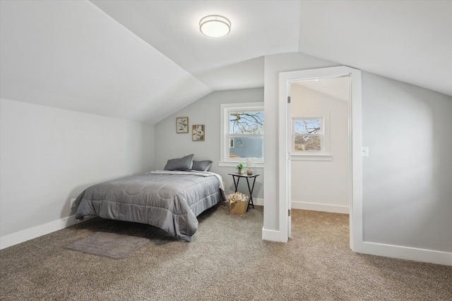 bedroom featuring light carpet, lofted ceiling, and baseboards