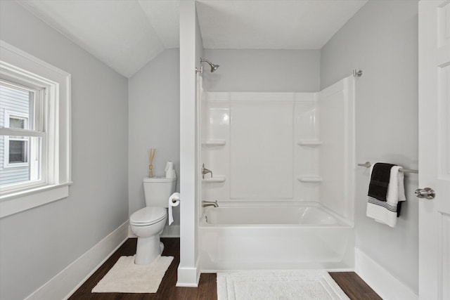 bathroom with baseboards, toilet, wood finished floors, and  shower combination