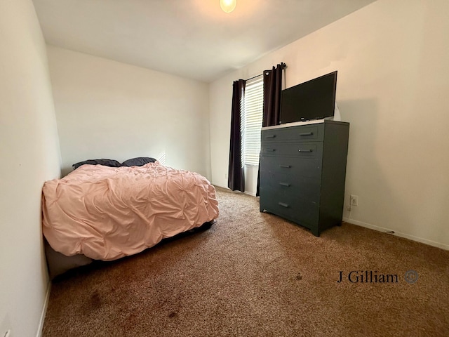 bedroom with light colored carpet and baseboards