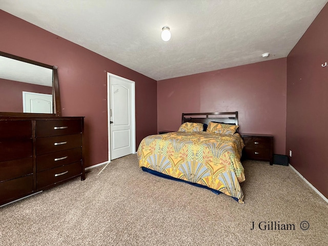 carpeted bedroom featuring baseboards and a textured ceiling