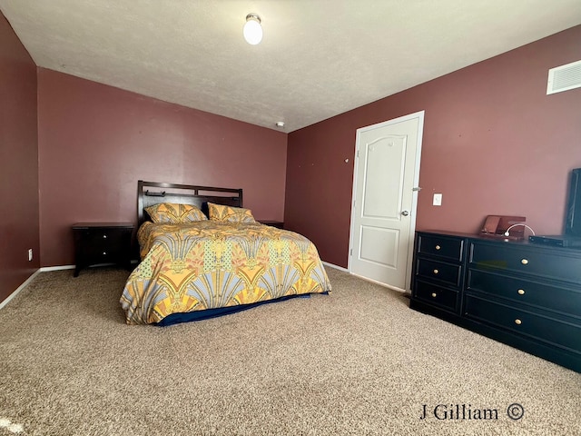 carpeted bedroom with visible vents, a textured ceiling, and baseboards