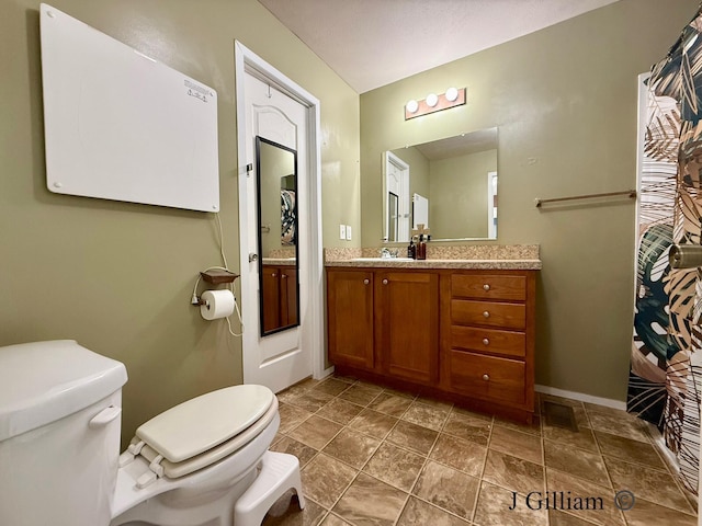 full bath featuring vanity, toilet, and baseboards