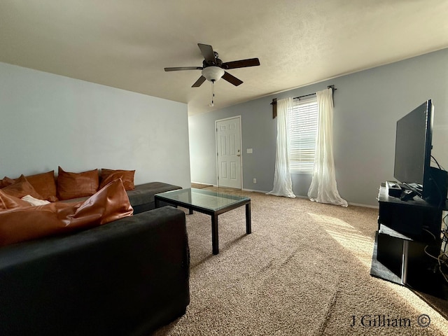 carpeted living area featuring baseboards and ceiling fan